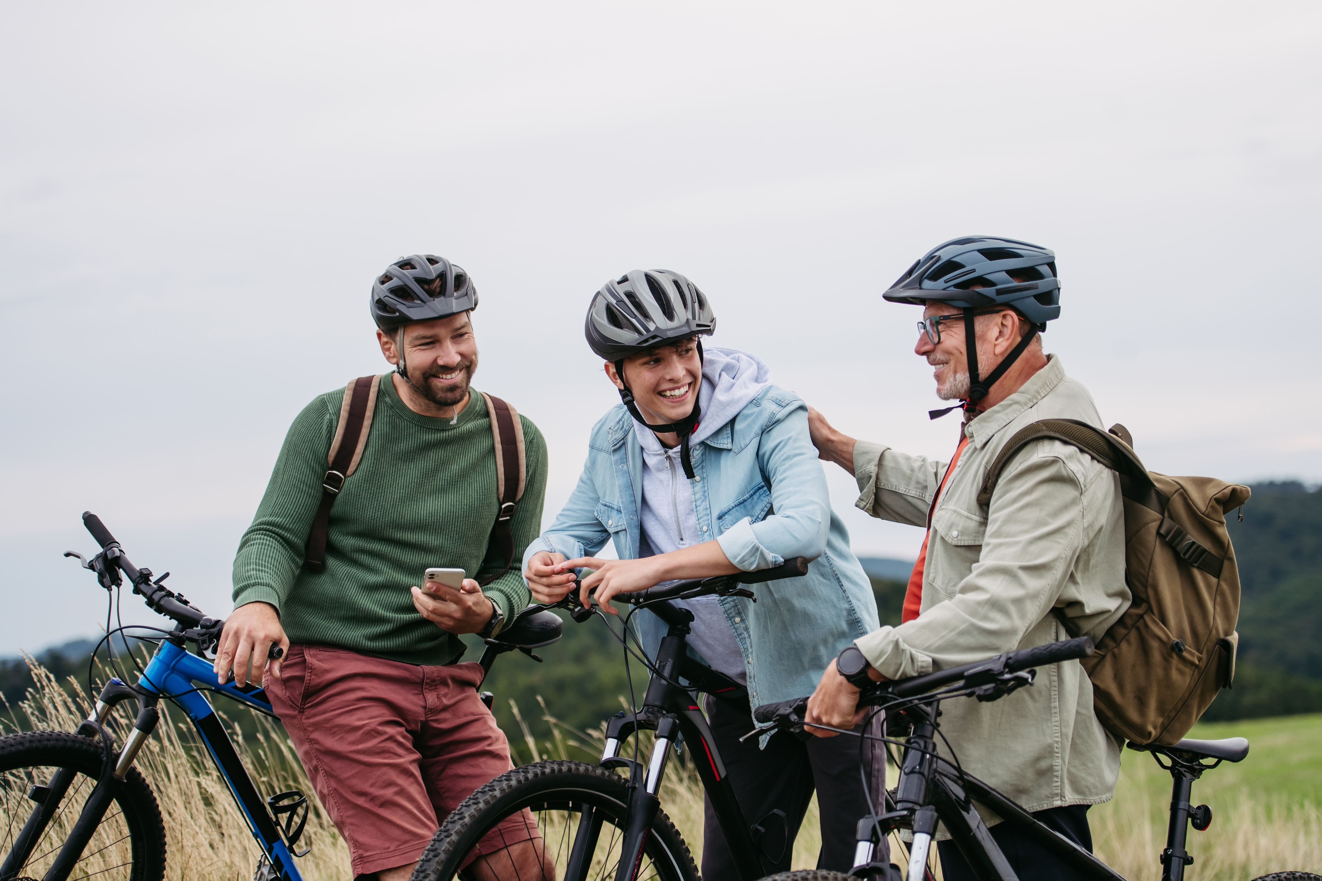 Grandfather, father and teen boy on cycling trip.